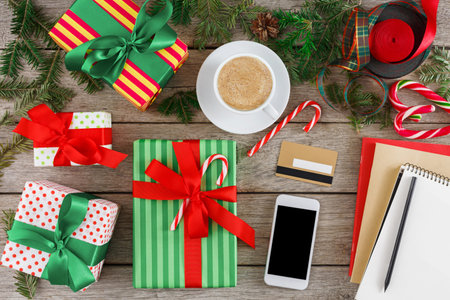 Collection of Wrapped Gifts, Hot Drink, and Stationery on Wooden Table During Holiday Season
