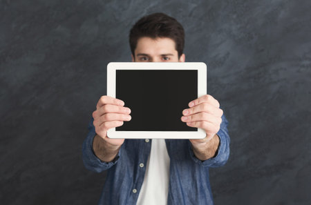 Handsome man holding digital tablet in studio