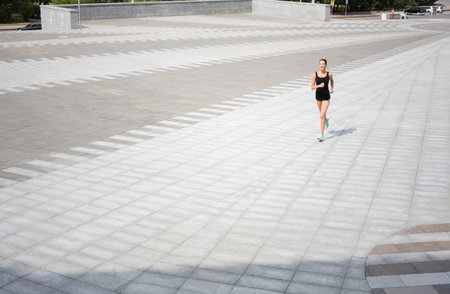 Runner Moves Across a Mosaic Pattern on a Large Outdoor Area in Bright Daylight