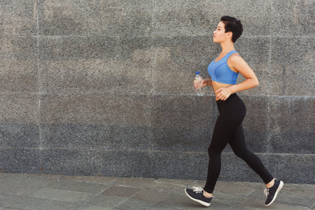Woman Walking and Exercising in a City Setting, Enjoying Outdoor Fitness Activity