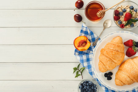 Croissants and Fresh Fruits Arranged on a Table for Breakfast Collection Displayの写真素材