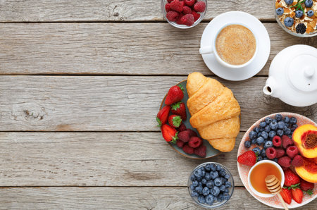 Breakfast Collection With Coffee, Fruit, and Pastries on Wooden Table