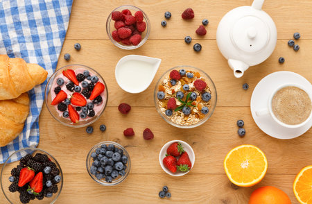 Breakfast Collection With Various Fruits, Yogurt, and Pastries on a Wooden Table