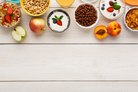Breakfast Spread Includes Fruits, Cereals, and Yogurt on White Wooden Table