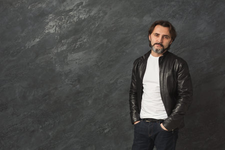 Portrait of Man in Black Leather Jacket With Gray Background in a Studio Setting