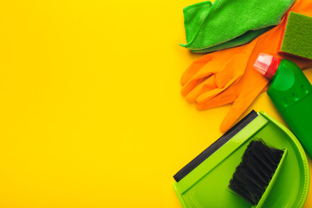 Cleaning Supplies Arranged in a Collage on a Bright Yellow Backdrop