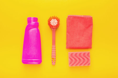 Cleaning Supplies Arranged in a Collage on a Bright Yellow Background for Effective Use