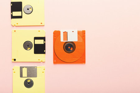 Collection of Floppy Disks Arranged in a Mosaic on a Pink Background