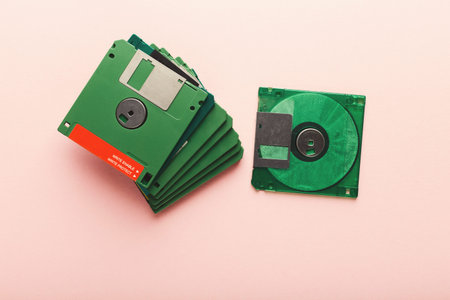 Collection of Green Floppy Disks Arranged on a Light Background With One Disk Beside the Stack