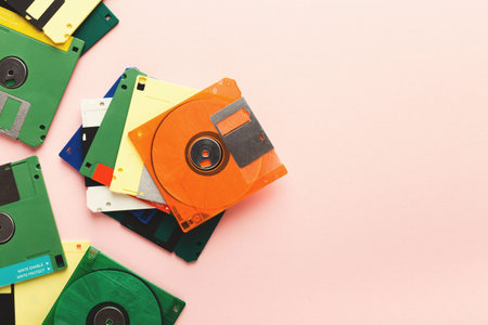 Collection of Colorful Floppy Disks Arranged on a Pink Background in a Collage Style