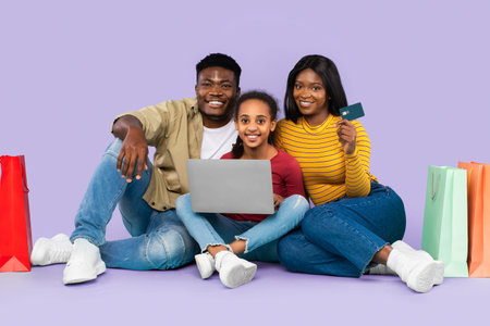 Family Enjoys Online Shopping With Laptop and Credit Card in Bright Setting With Shopping Bags