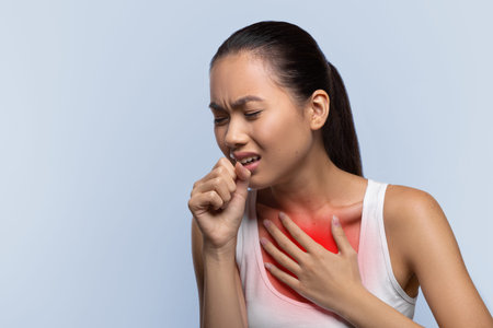 Woman Coughs and Holds Chest While Experiencing Discomfort in Her Body