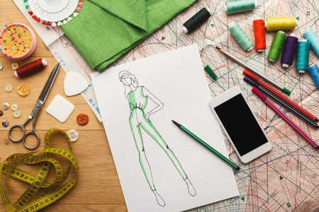 Creative Collection of Sewing Tools and Fashion Design Sketches on a Workspace