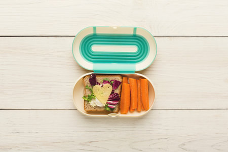 Creative Food Collage in a Lunchbox With Vegetables and Sandwich