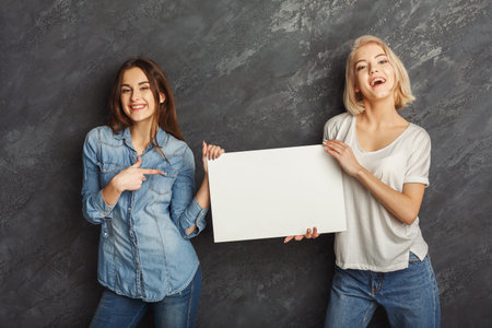 Collage of Two Women Holding a Blank Sign in Front of a Gray Wall