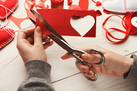 Crafting a Heart Collage With Scissors and Red Paper During a Creative Session