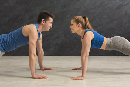 Couple making plank or push ups exercise indoors