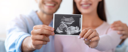 Couple Shares Joy of Pregnancy Through Ultrasound Image Holding in Home Setting