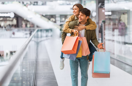 Couple Enjoys Shopping Together at a Mall While Carrying Multiple Shopping Bagsの写真素材