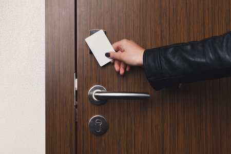 Hand Inserting Keycard Into Hotel Door Lock in a Hallway Setting at Check-In Time