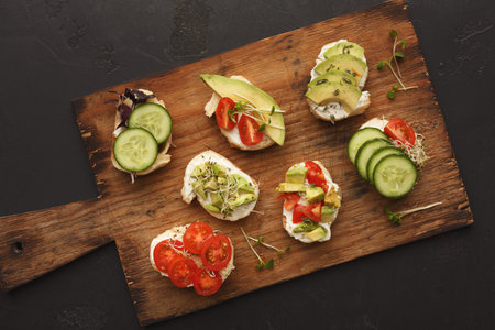 Collection of Open-Faced Sandwiches With Fresh Vegetables on a Cutting Board