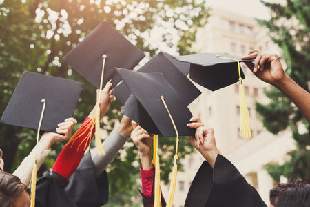 Graduation Caps Are Raised in Celebration at a University Campus During a Sunny Ceremony