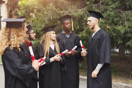 Group of Students Celebrate Graduation With Diplomas Outside on a Sunny Day in the Park