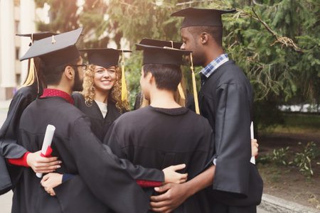Graduates Celebrate Together Outdoors at a University During Graduation Ceremonyの写真素材
