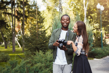 Couple Enjoys Time Together While Taking Pictures in a Sunny Park Setting