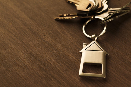 Collection of Keys With House Keychain on a Wooden Table in a Simple Setting