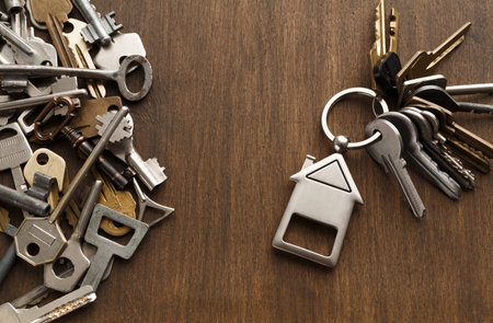 Collection of Keys Arranged in a Collage Format on a Wooden Surface With a House-Shaped Keychain