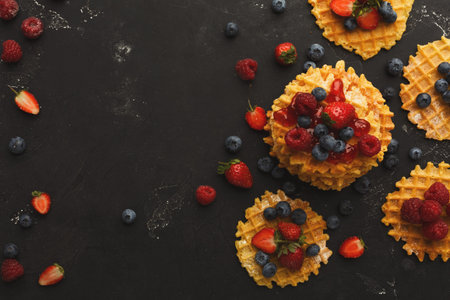Delicious Waffle Collection Topped With Fresh Berries on a Dark Surface