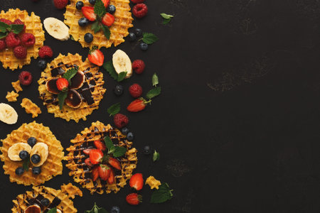 Waffles With Fruits Arranged in a Mosaic Style on a Dark Backgroundの写真素材