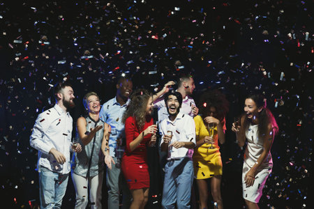 Group of Friends Celebrate With Confetti at a Fun Gathering During Late Evening Hoursの写真素材