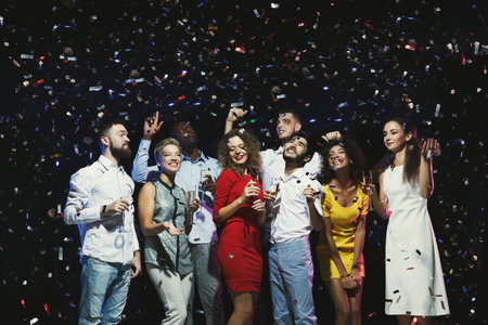 Group Celebration With Confetti and Drinks During a Joyful Night Event