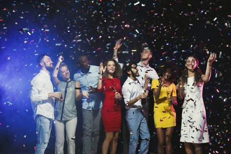 Collection of People Celebrating During a Party With Confetti at Night in a Lively Setting
