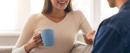 Two People Having a Conversation While Enjoying Coffee in a Cozy Living Room Setting