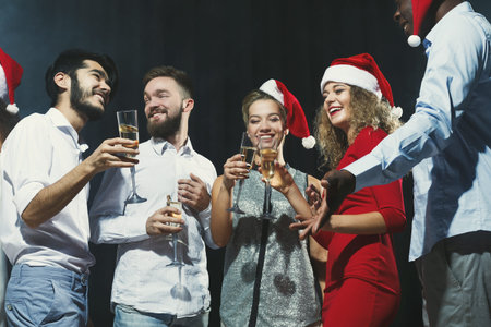 Group of Friends Celebrate Holiday Season With Drinks and Smilesの写真素材