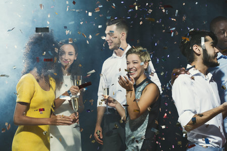 People Celebrating at a Party With Confetti and Drinks in a Lively Setting