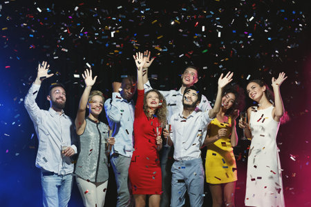 Group Celebrates With Drinks and Confetti in a Lively Party Setting at Night