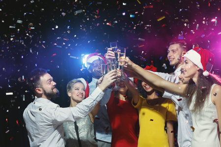 Group of Friends Celebrate With Drinks and Confetti at a Party During the Holiday Season
