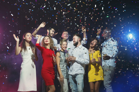 Group of People Celebrating With Confetti During a Festive Event at Night Time