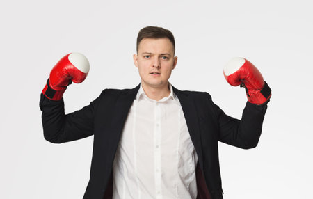 Businessman in boxing gloves flexing bicepsの写真素材