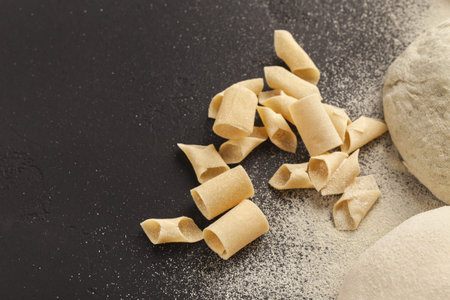 Handmade Pasta on a Black Surface With Scattered Flour and Dough Pieces in a Collection