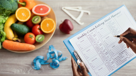 Planning Meals Using a Clean Eating Chart and Fresh Produce at a Kitchen Table in Morning Light
