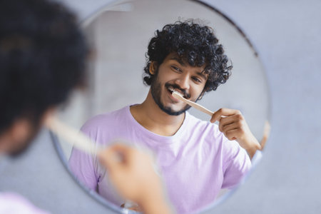 A Man Stands in Front of a Round Mirror Brushing His Teeth