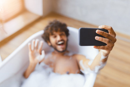 Man Takes Selfie in Bathtub With Bubbles During Leisure Time at Home