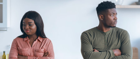 Young Couple Conflict. Offended Black Man And Woman Standing In Kitchen