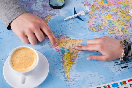 Travel Planning Session Over a World Map With Coffee and Model Plane