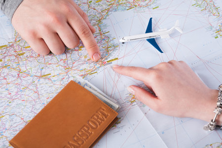 Planning a Travel Route With a Map, Passport, and Model Airplane on the Table